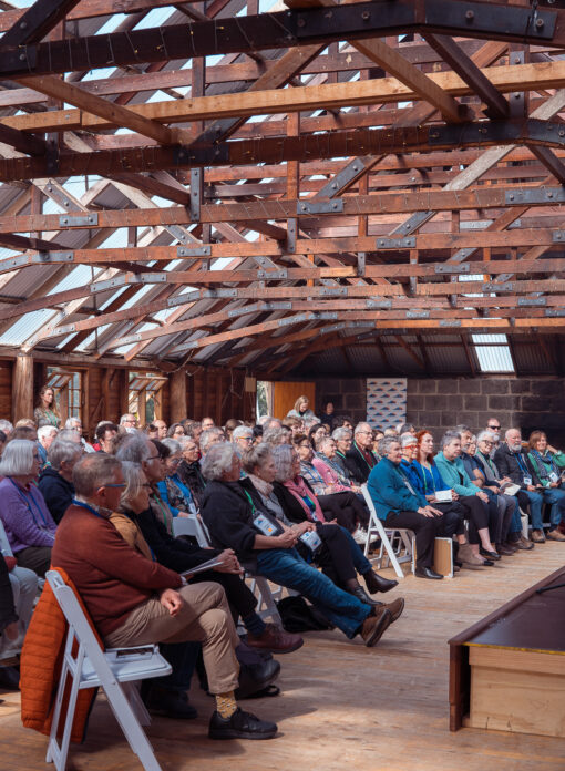 Interior of Mt Sturgeon Woolshed with seated audience facing a stage